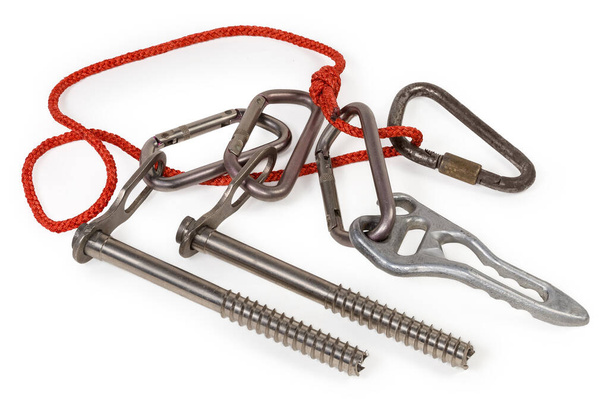 Ice screws, several different carabiners on the rope loop and vintage climbing descender on a white background - Photo, Image