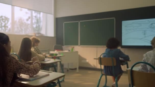 Школярки сидять за столами в класі під час уроку в початковій школі
 - Кадри, відео