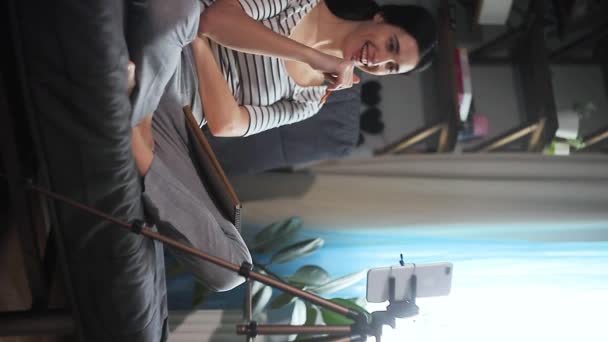Dziewczyna siedzi na kanapie w domu i rozmawia przez łącze wideo z telefonu. Pojęcie szkolenia lub strumieni. - Materiał filmowy, wideo