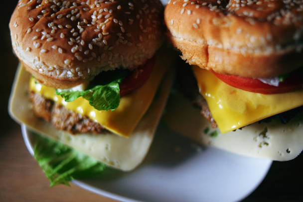 Fotos de hamburguesas caseras. Filete y bollo blanco con semillas de sésamo, queso y col, tomates. Comida casera. - Foto, imagen
