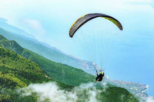 Летающий параплан над озером Гарда в Малчезине, Италия - Фото, изображение