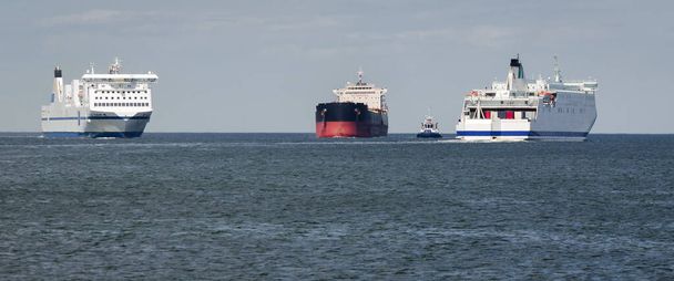 TRANSPORTE MARÍTIMO - Transbordadores de pasajeros y graneleros en la vía navegable hasta el puerto  - Foto, Imagen