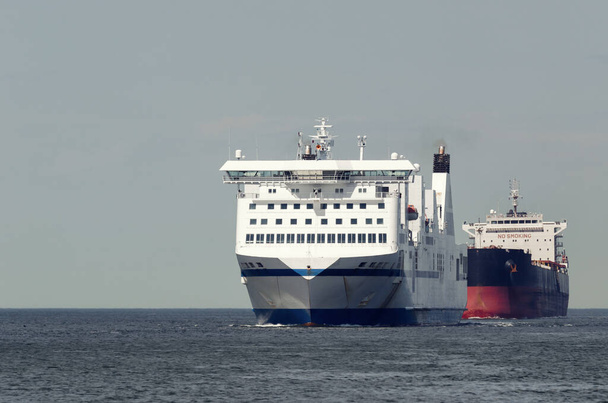 MARITIME TRANSPORT - Passagiersveerboot en bulkcarrier op de binnenwateren naar de haven  - Foto, afbeelding