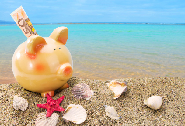 Piggy bank on sand with summer sea background - Photo, Image