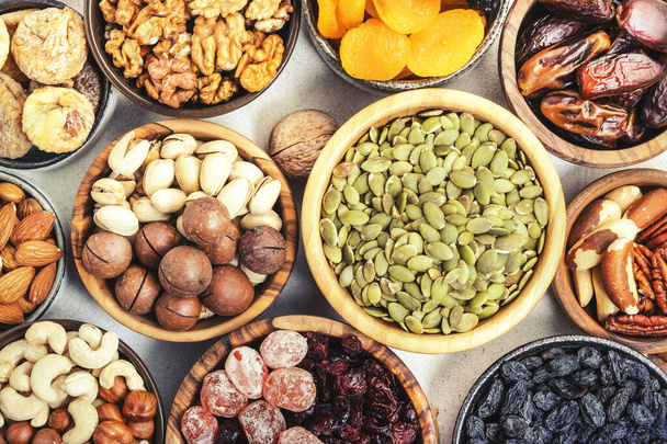 Nuts and dried fruits. Dried apricots, figs, raisins, pecans, walnuts, hazelnuts, almonds and other. White background, top view - Foto, Imagem