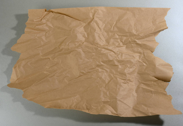 pedaço de papel marrom de hortelã com bordas rasgadas e sombra no fundo cinza. Cenário criativo abstrato para designer - Foto, Imagem