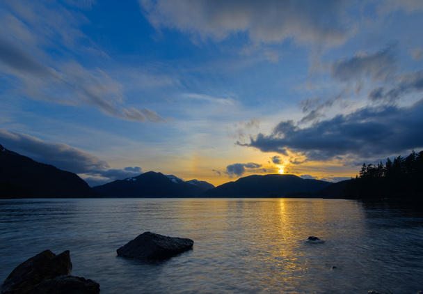 gele zonsondergang over bergen naast lake - Foto, afbeelding