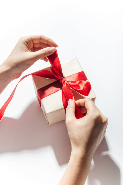 Woman hands wrapping a gift on a white background - Photo, Image