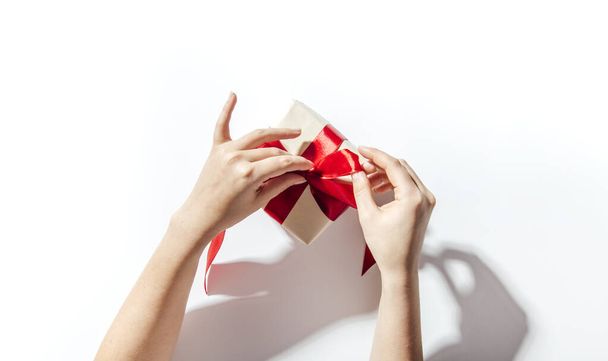 Woman hands wrapping a gift on a white background - Fotó, kép