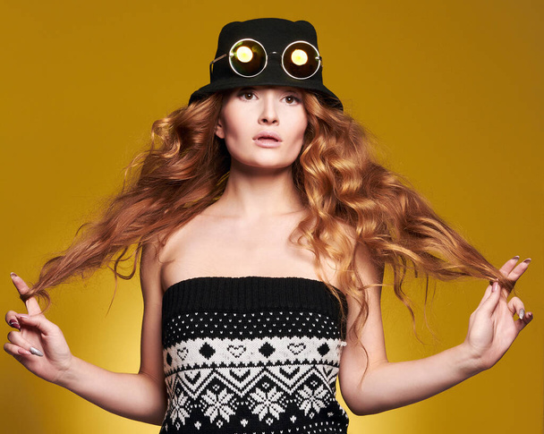 Beautiful woman in hat and sunglasses. Curly Red Hair girl. beauty fashion portrait - 写真・画像