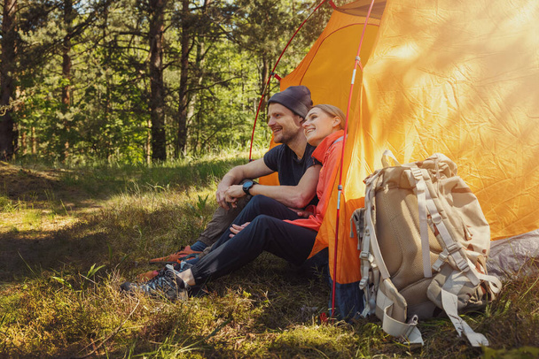 campeggio - giovane coppia seduta in tenda al campeggio e rilassante dopo l'escursione - Foto, immagini