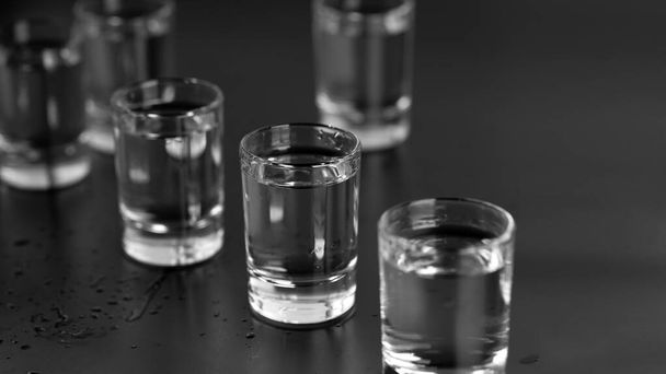 Wodka, rum, tequila, gin worden in glazen gegoten aan de bar.. - Foto, afbeelding