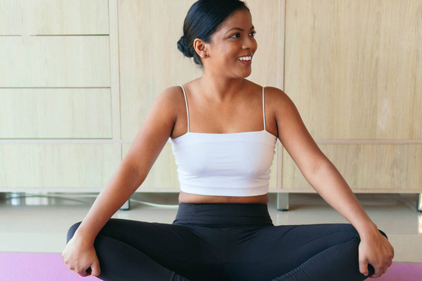 Jonge zwarte sportvrouw die thuis yoga beoefent. Wellness concept - Foto, afbeelding