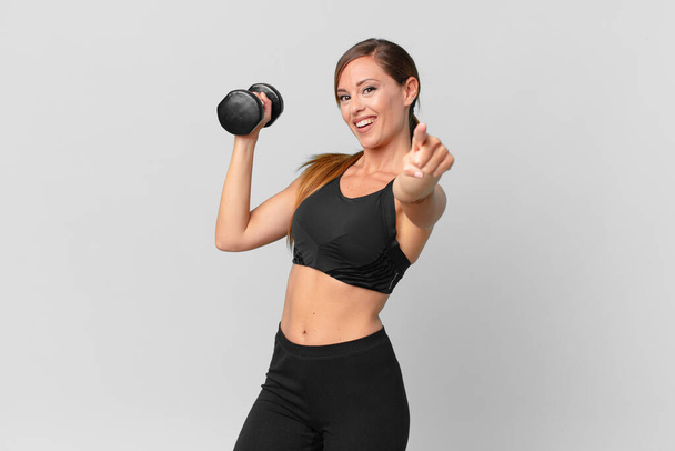 young pretty woman fitness concept and lifting a dumbbell - Foto, afbeelding