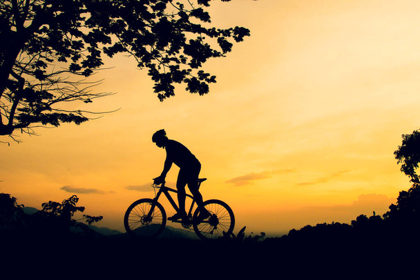 Une silhouette d'un VTT pratiquant le vélo sur une haute montagne - Photo, image