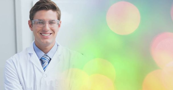 Composition of smiling male doctor, with colourful blurred copy space to right. medical and science research concept digitally generated image. - Foto, Imagen