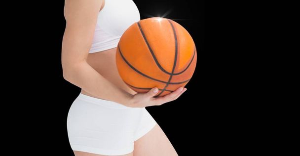 Composition of midsection of fit woman holding basketball and copy space on black background. sport and competition concept digitally generated image. - Fotoğraf, Görsel