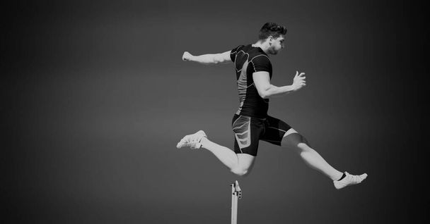 Composition of male hurdle jumper with copy space in black and white. sport and competition concept digitally generated image. - Фото, изображение
