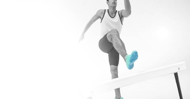 Composition of male athlete hurdle jumping with copy space on white background. sports and competition concept digitally generated image. - Foto, afbeelding