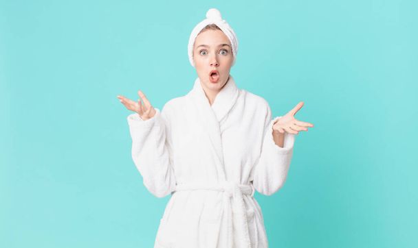 blond pretty woman feeling extremely shocked and surprised and wearing bathrobe - Fotografie, Obrázek