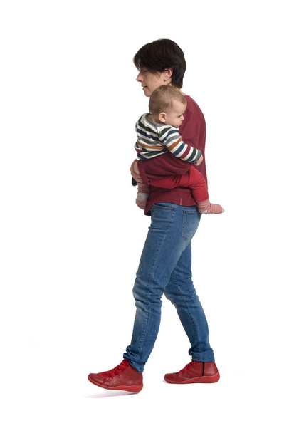 walking of a mother carrying her baby on white background - Photo, Image