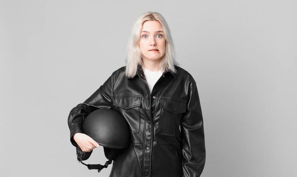 blond pretty woman looking puzzled and confused. motorbike rider concept - Φωτογραφία, εικόνα