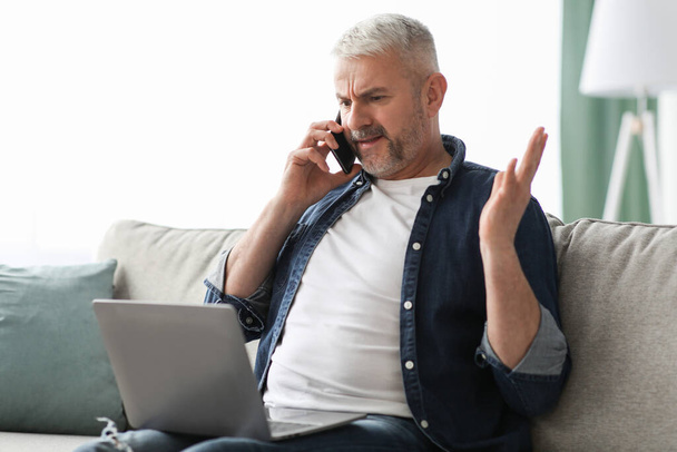 Angry mature man having phone fight with Internet provider - Foto, afbeelding