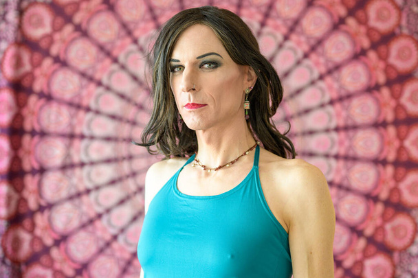 Upper body portrait of a transgender man with a serious emotion in front of a colorful background - Photo, Image