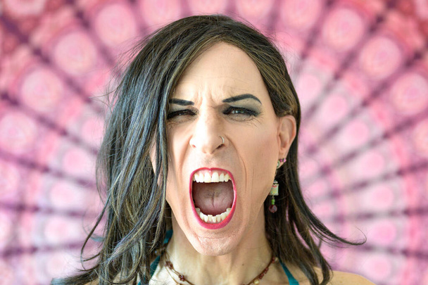 Porträt eines weinenden Transgender-Mannes mit weit geöffnetem Mund - Foto, Bild