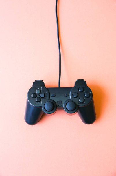 Joystick leží na růžovém pozadí. Gamepad pro hraní počítačových her. - Fotografie, Obrázek