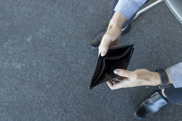 Nahaufnahme leere Brieftasche (kein Geld) in den Händen eines Mannes mit Softfokus und Überlicht im Hintergrund - Foto, Bild