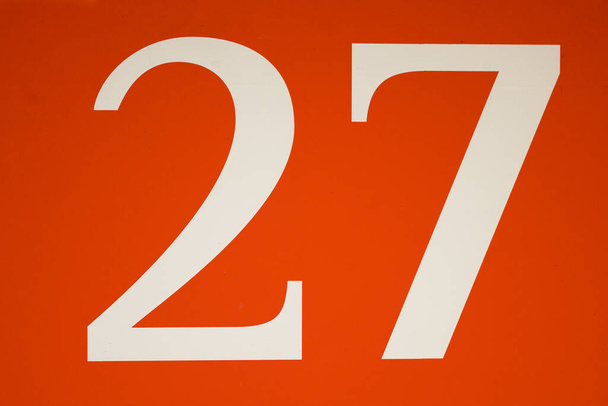 Kolorowy czerwono-biały znak z numerem dwadzieścia siedem - 27 - wzorzyste w centrum w pełnym widoku ramki - Zdjęcie, obraz