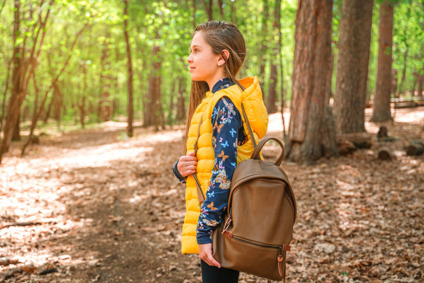 Mała dziewczynka z plecakiem spaceruje po wiosennym lesie, czas relaksu, pojęcie zdrowia psychicznego - Zdjęcie, obraz