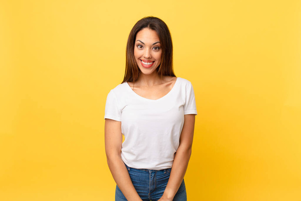 young hispanic woman looking happy and pleasantly surprised - Foto, Imagen