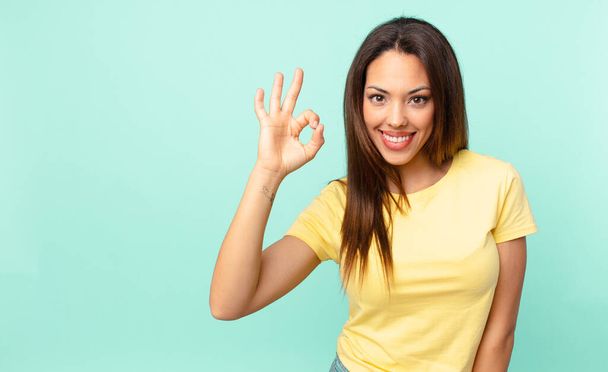 young hispanic woman feeling happy, showing approval with okay gesture - Fotó, kép