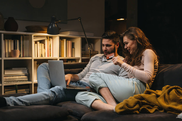 couple enjoying evening together at home. they shopping online - Valokuva, kuva