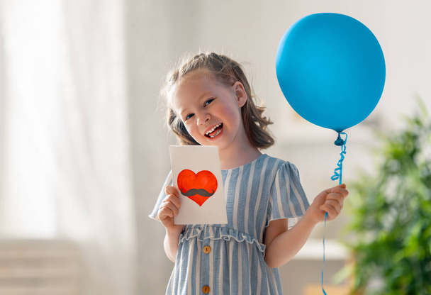 Szczęśliwe dziecko z balonem i pocztówką dla ojca. - Zdjęcie, obraz