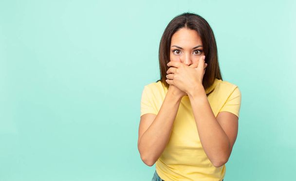 young hispanic woman covering mouth with hands with a shocked - Foto, Imagen