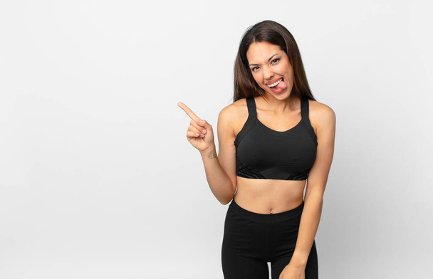 young hispanic woman with cheerful and rebellious attitude, joking and sticking tongue out. fitness concept - Φωτογραφία, εικόνα