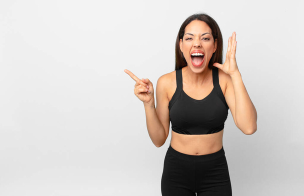 young hispanic woman screaming with hands up in the air. fitness concept - Zdjęcie, obraz