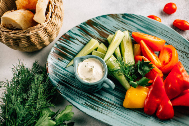 plateau de légumes frais hachés et sauce avec du pain dans le panier sur la table, vue rapprochée  - Photo, image