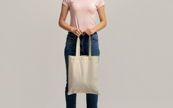 Koniec z plastikiem. Przycięte zdjęcie kobiety trzymającej pusty biały eko torba - Zdjęcie, obraz