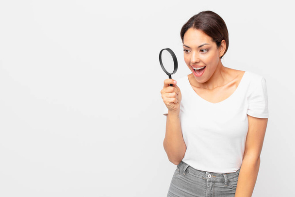 young hispanic woman holding a magnifying glass - Photo, image