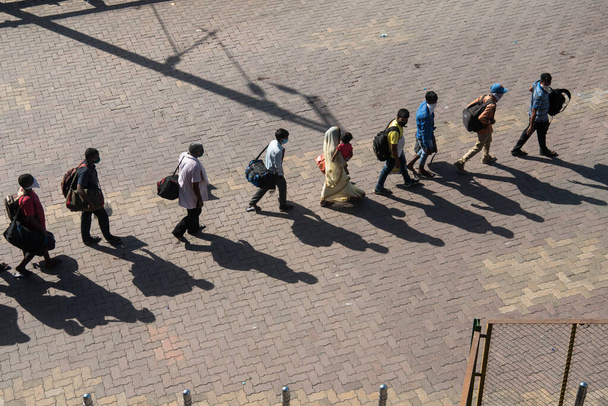 MUMBAI/INDIA - MAY 30, 2020: Migrant workers stand in queue arrives at Lokmanya Tilak railway terminus for boarding a special train on their journey back home during a nationwide lockdown as a preventive measure against the spread of the coronavirus - Φωτογραφία, εικόνα