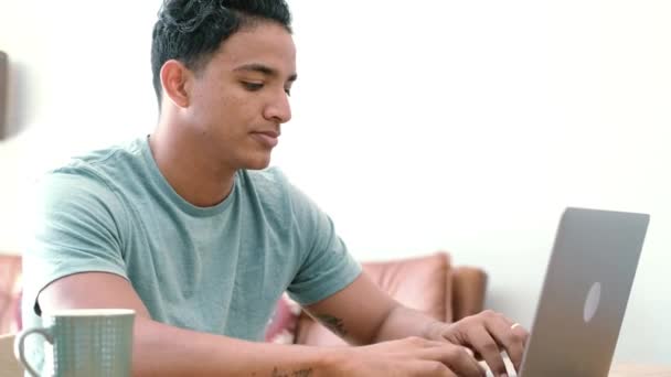 Σύγχρονος μαύρος νεαρός άνδρας εργάζεται στο σπίτι με φορητό υπολογιστή που σερφάρει στο διαδίκτυο. Συνδεδεμένοι άνθρωποι δραστηριότητα στο τραπέζι στο γραφείο στο σπίτι εργασίας. Έννοια της έξυπνης επιχείρησης εργασίας - Πλάνα, βίντεο
