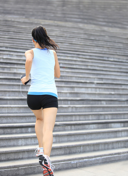 Runner athlete running on stairs listening to music - Фото, изображение