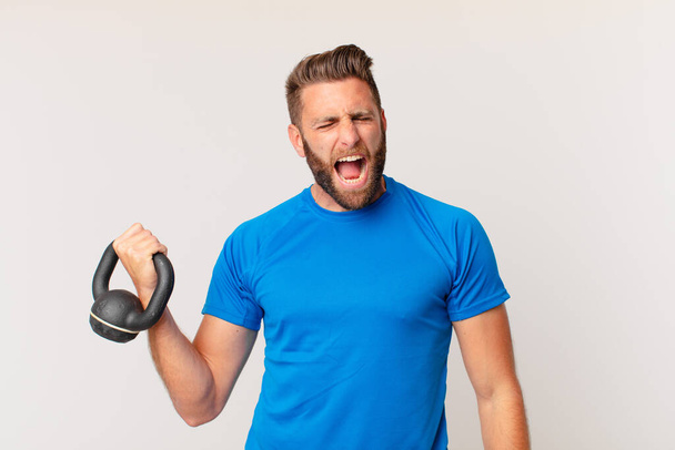 young fitness man lifting a dumbbell - 写真・画像