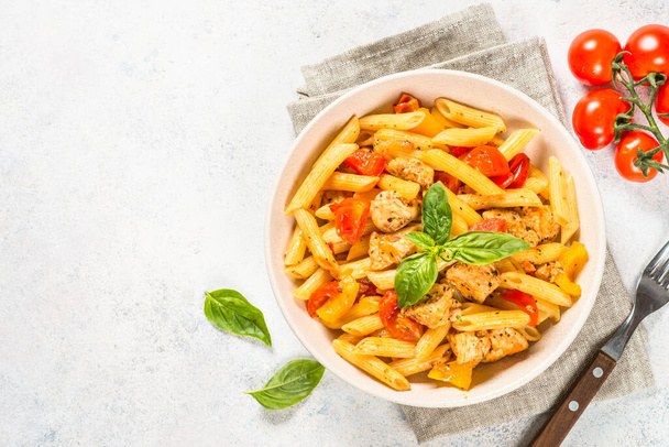 Pasta with chicken and vegetables at white table. - Photo, Image