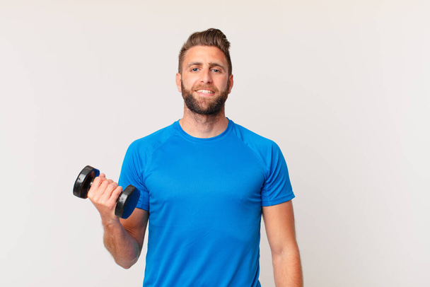 young fitness man lifting a dumbbell - Foto, Imagen