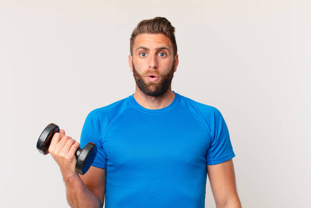young fitness man lifting a dumbbell - Foto, afbeelding